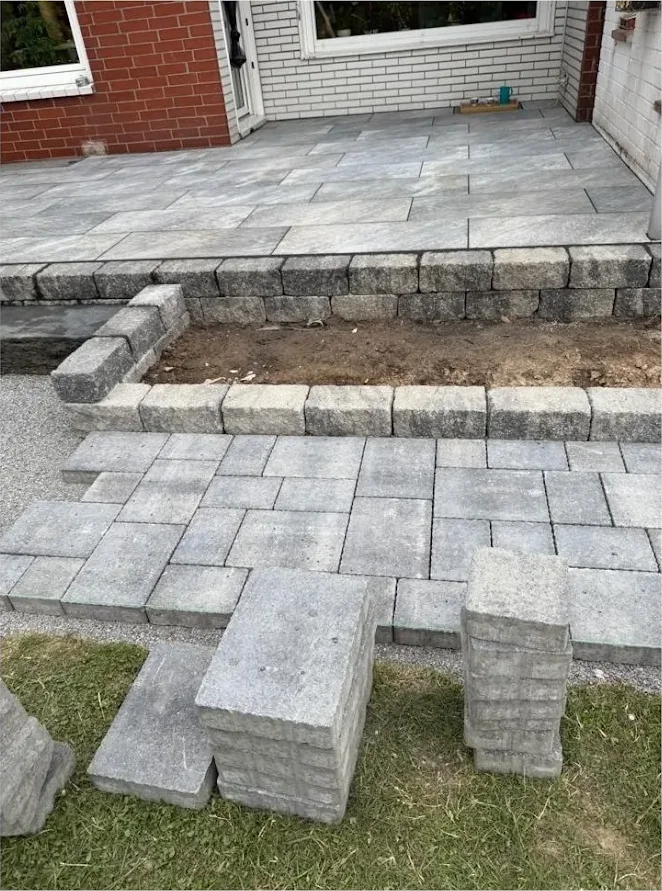 Granitmauer und Pflasterfläche vor dem Hauseingang