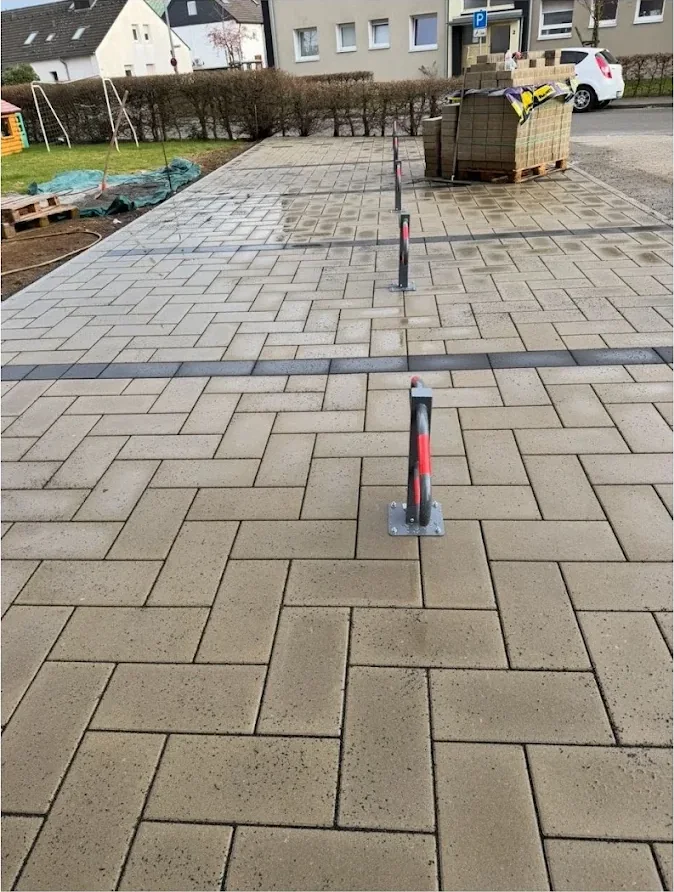 Große gepflasterte Parkfläche mit Pollern